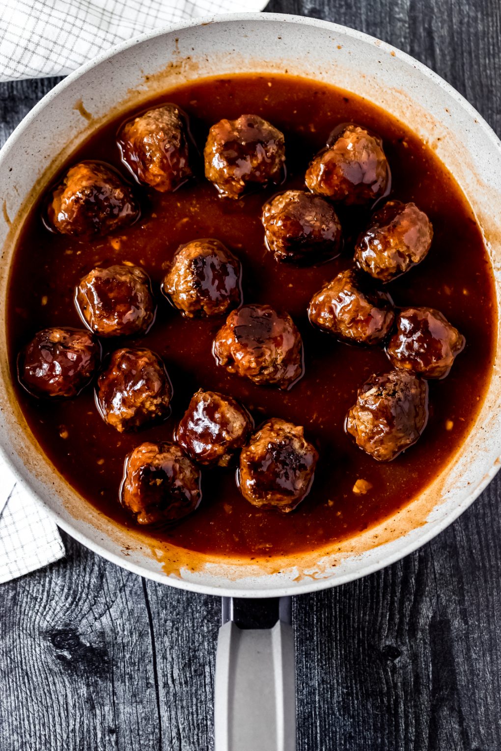 venison meatballs in a skillet covered in BBQ bourbon sauce