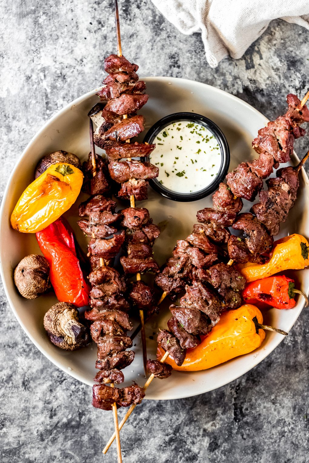 skewers of grilled venison kabobs and vegetables in a bowl