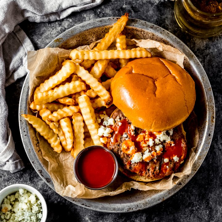 a spicy buffalo bison burger in a dish with fries and buffalo sauce