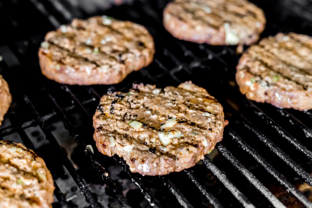 spicy buffalo bison burgers cooking on a grill