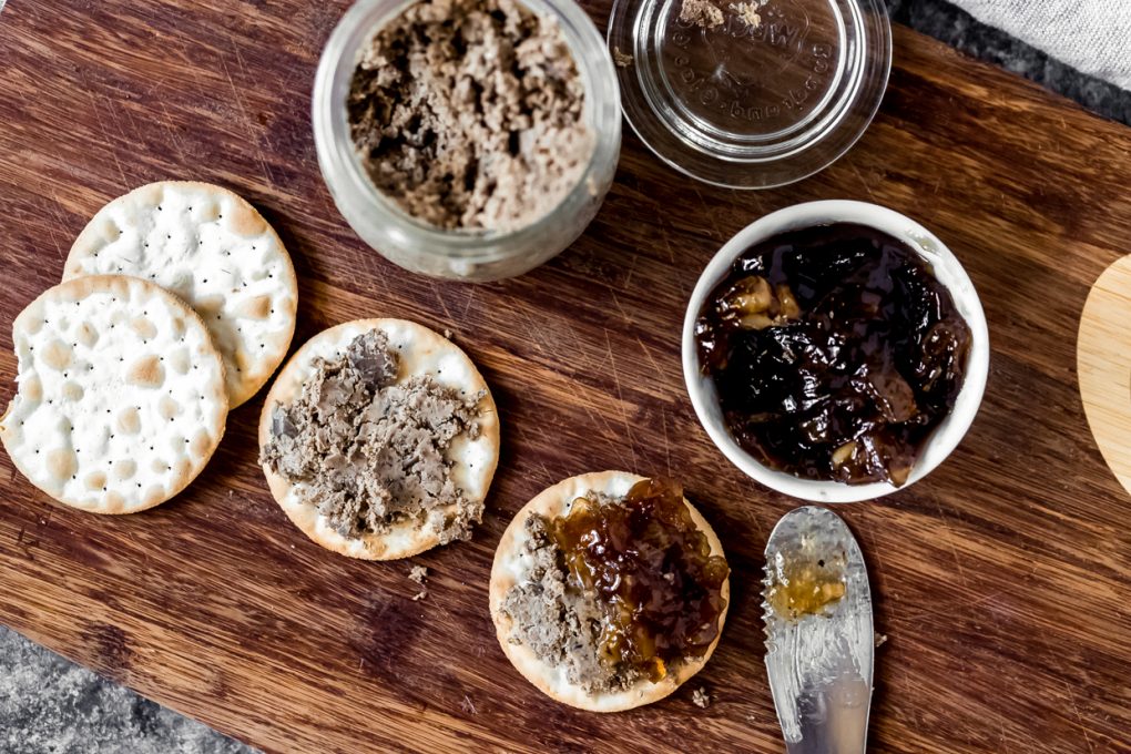 elk liver pate on a cutting board with onion jam and crackers