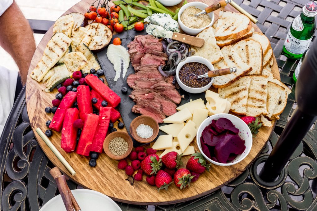a large graze board featuring wild game steak and fresh ingredients