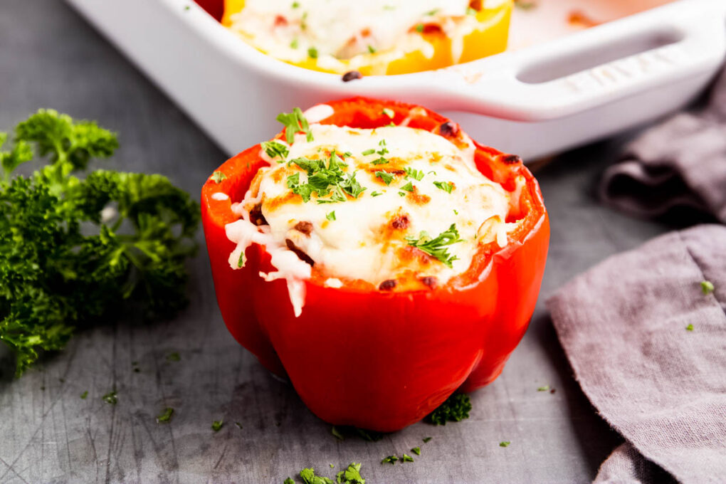 Red stuffed bell Pepper in front of casserole dish