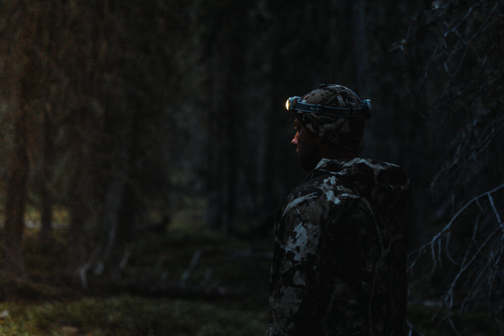 a man hunting with a head lamp on