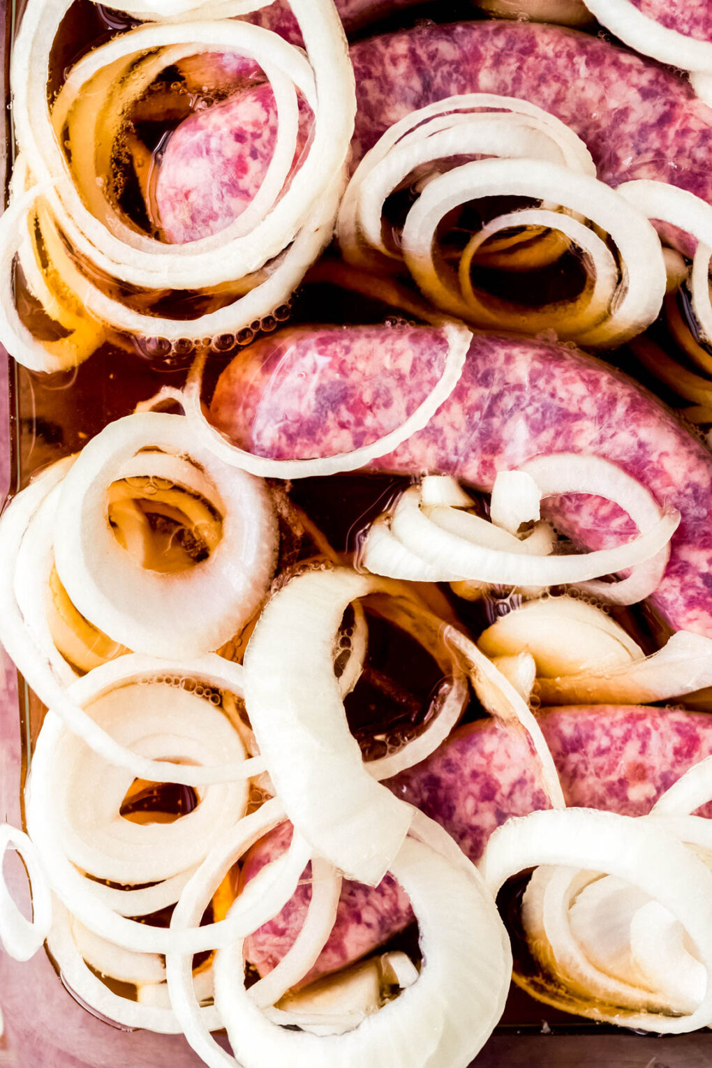 brats and onions marinating in beer